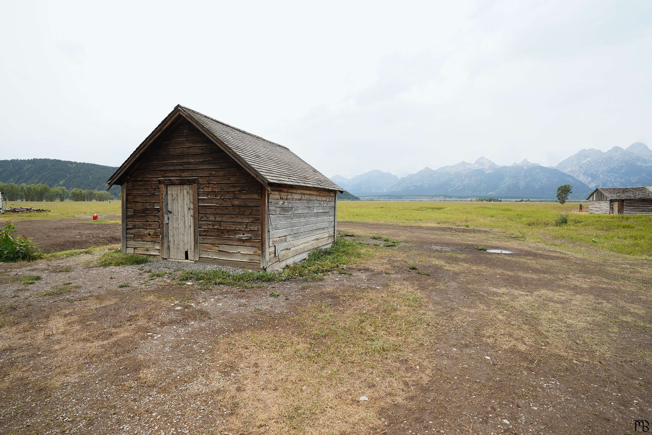 An old shed in front of the mountains