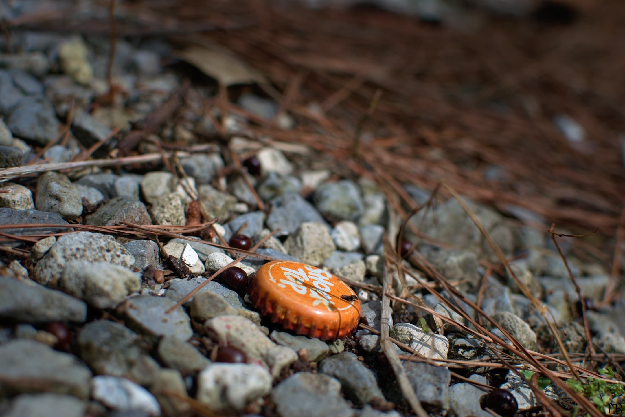 Orange bottle cap on rocks