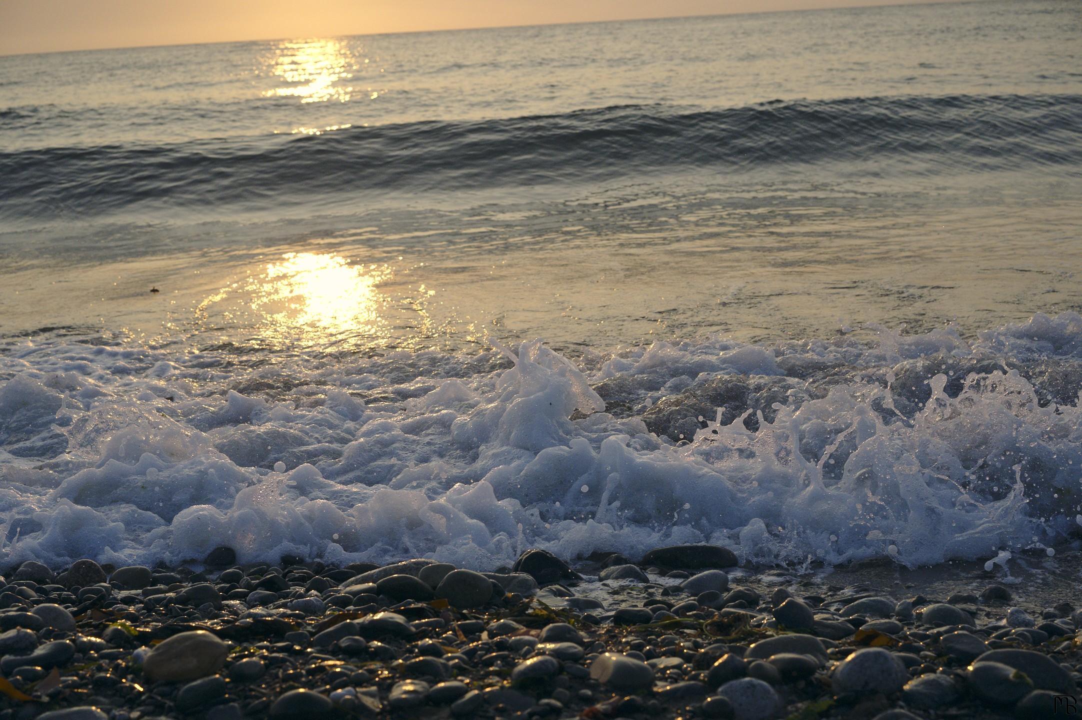 Waves crashing against stony beach