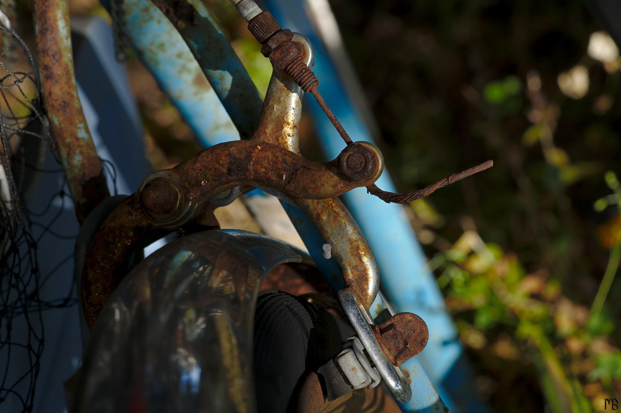 Rusty bike brake above grass