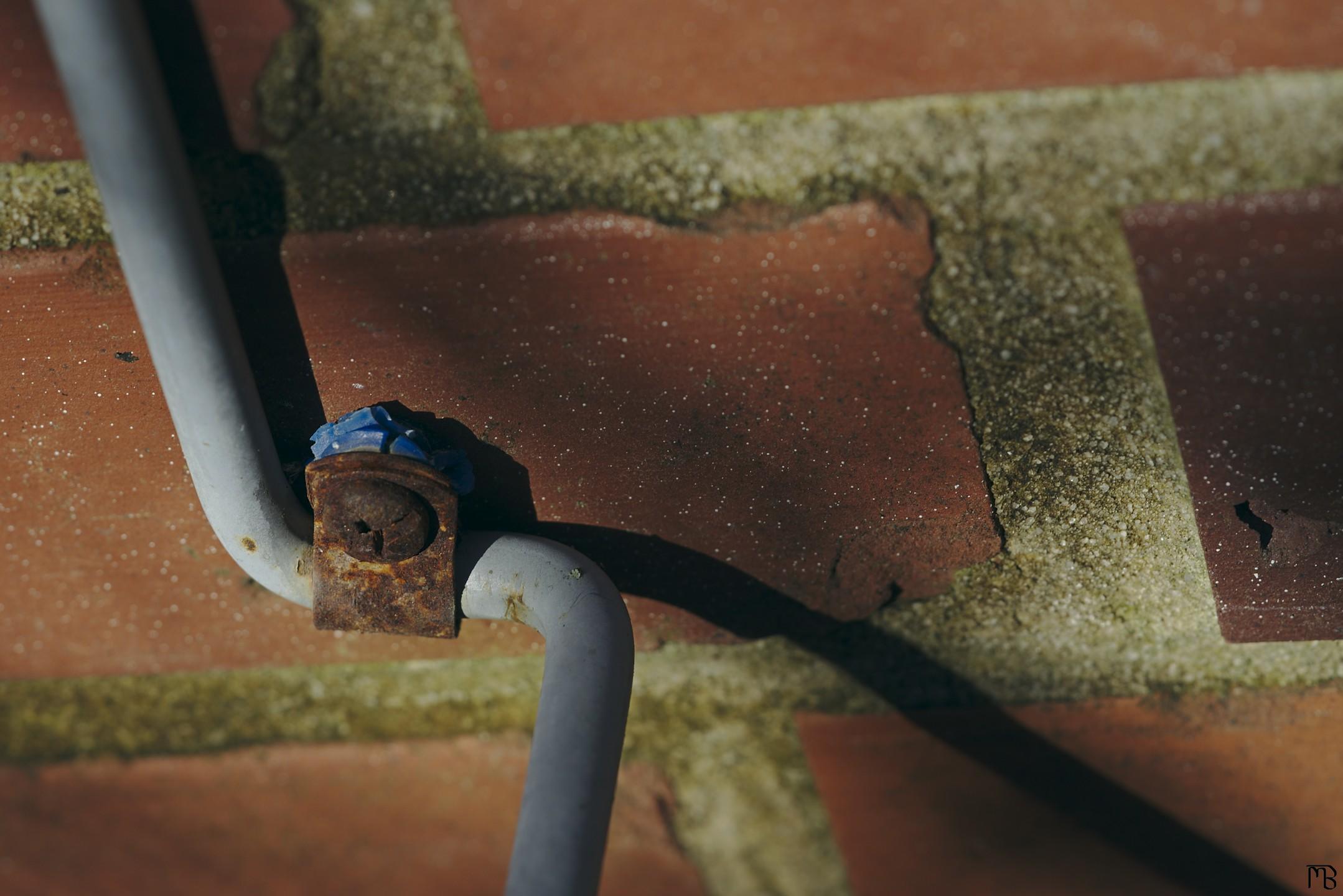 Rusty screw in brick wall