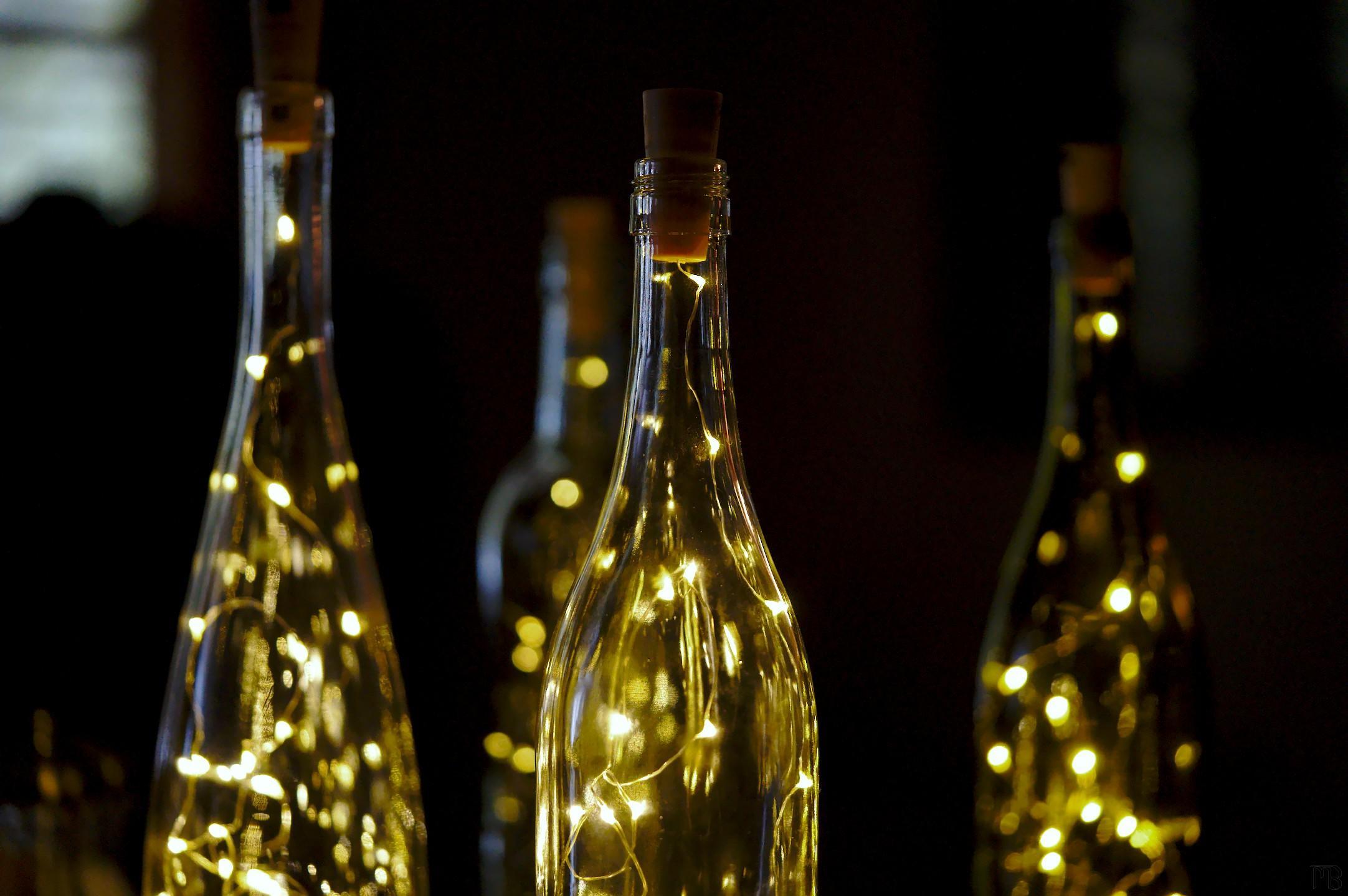 Four centered bottles with yellow lights