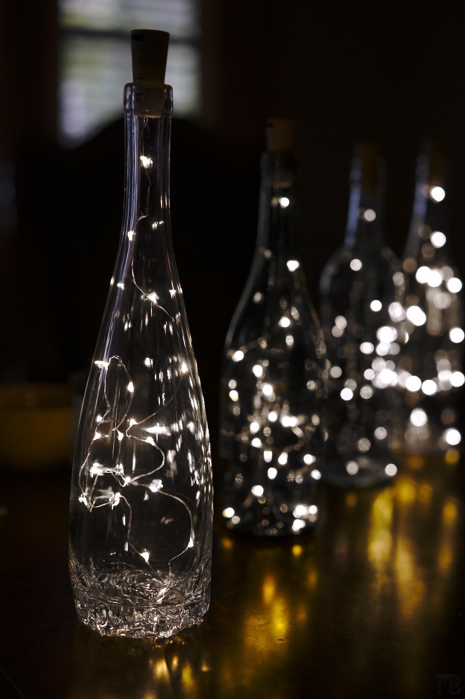 Arty bottles with white lights in a line