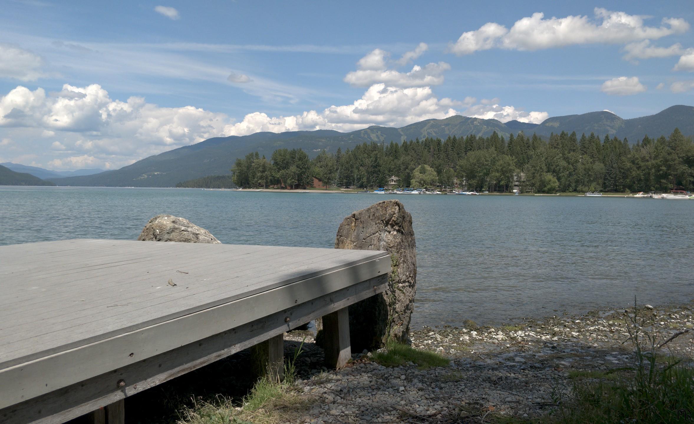 Platform near lake, trees, and mountains