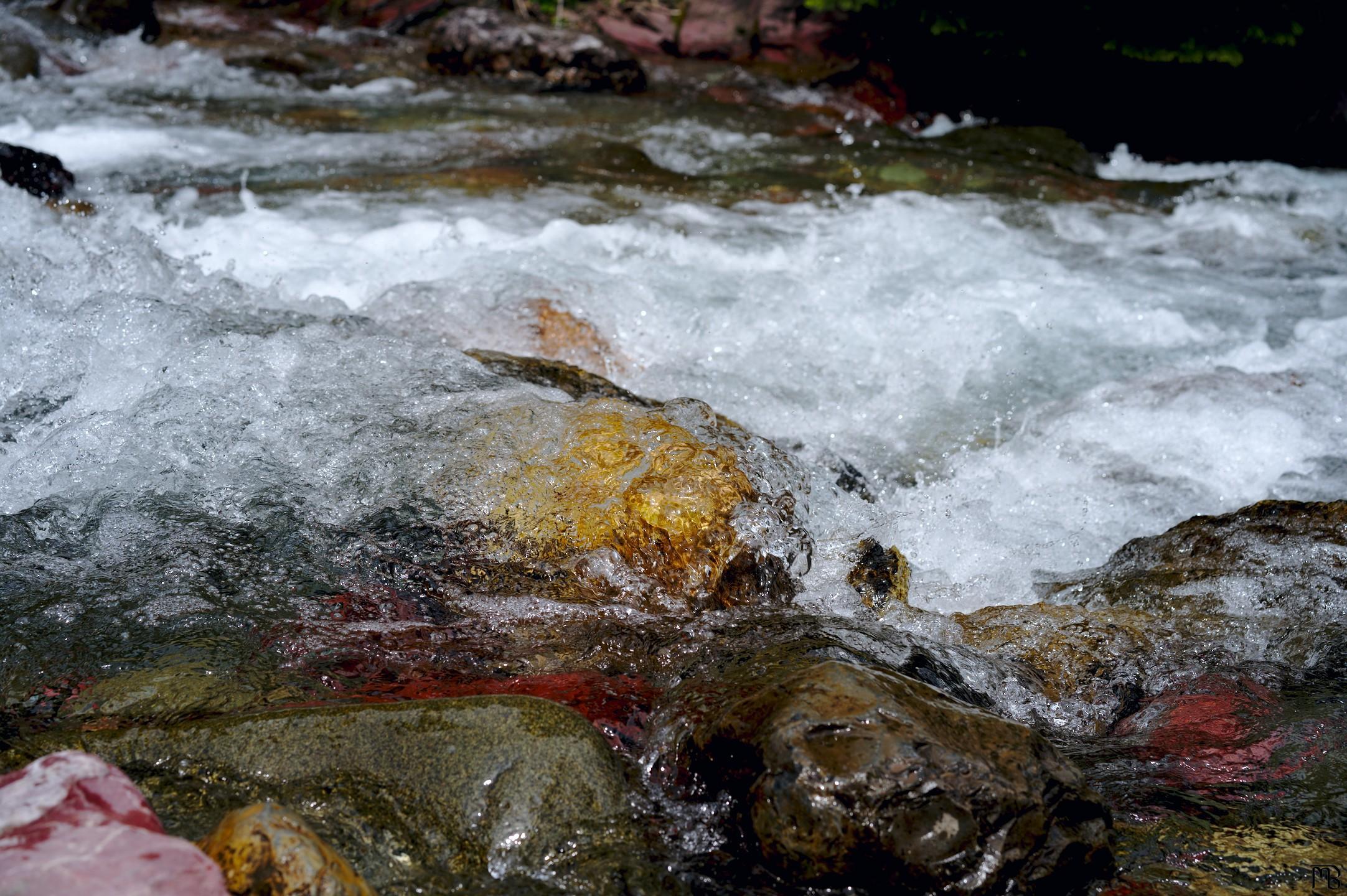 Water rushing over orange-y rock