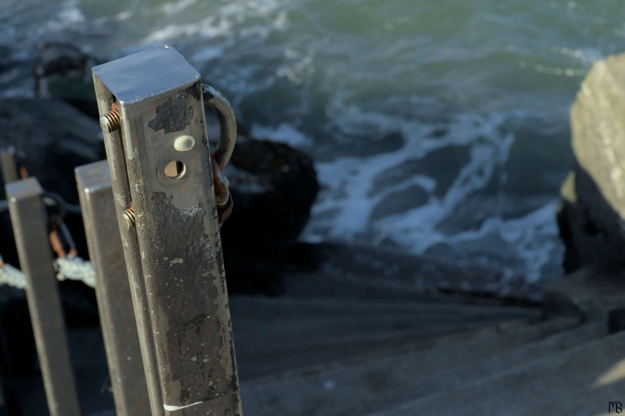 Steel gate above sea water on stairs