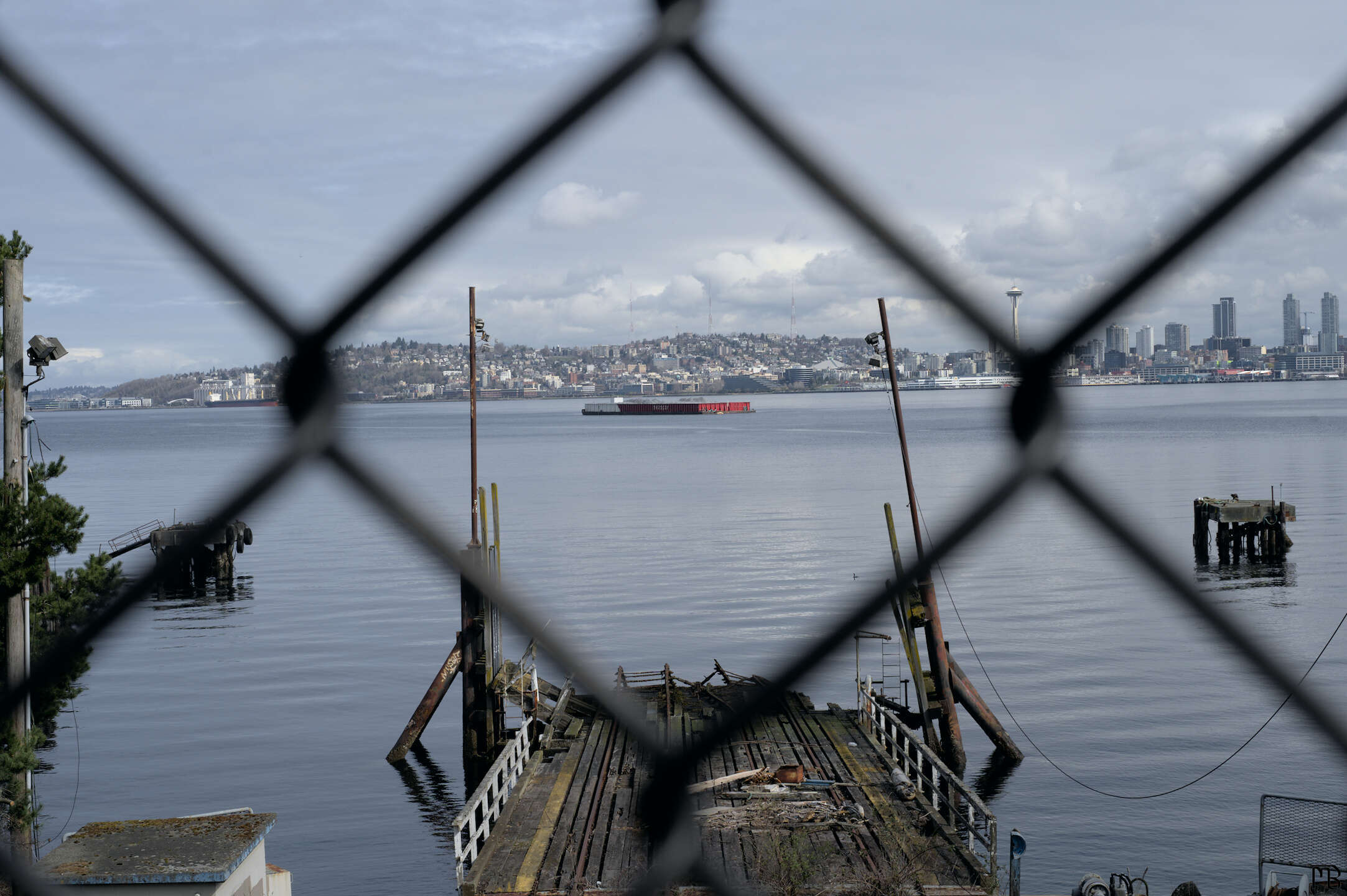 Floating red barge through a chain link fence