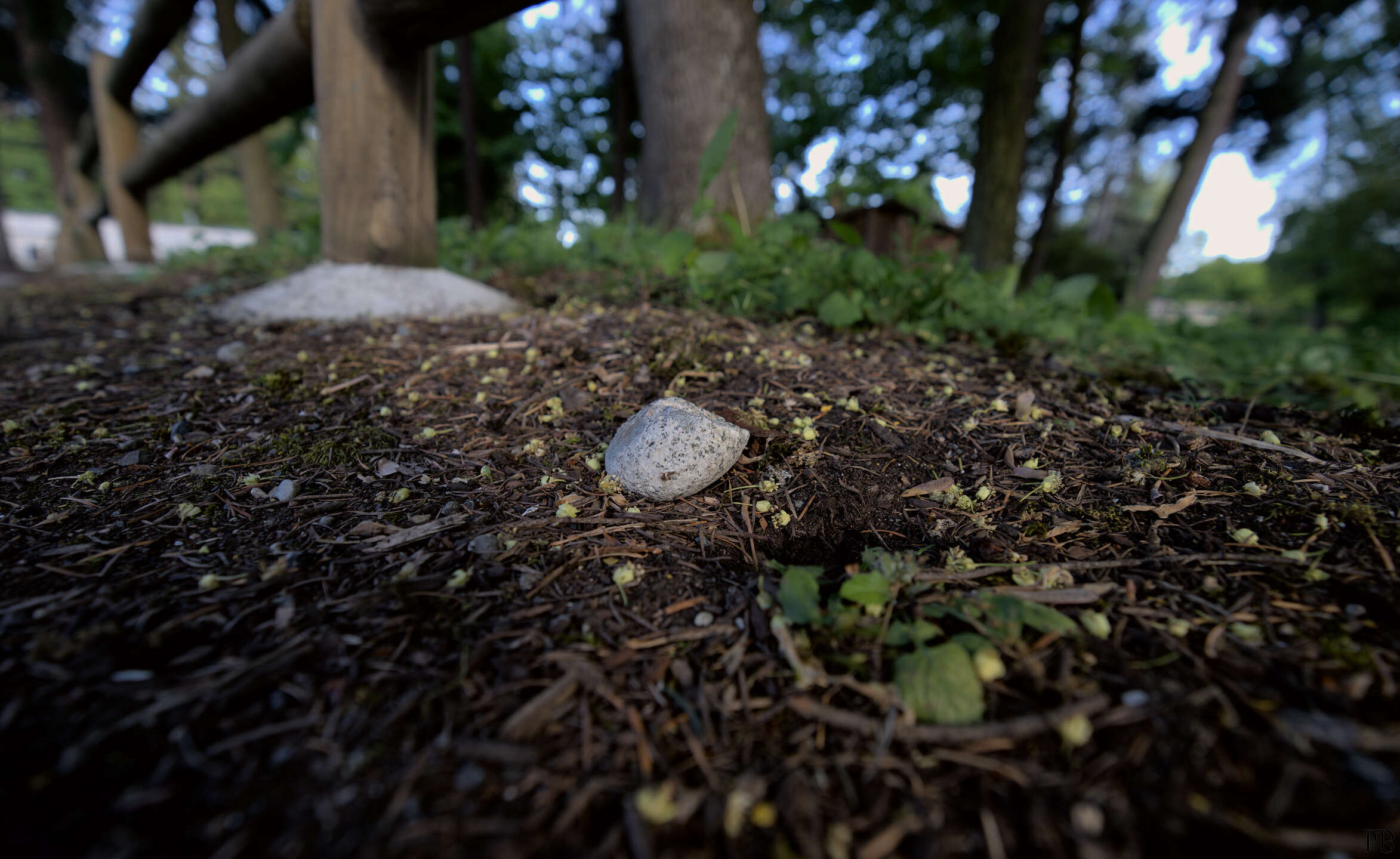 Small stone under wooden post fence