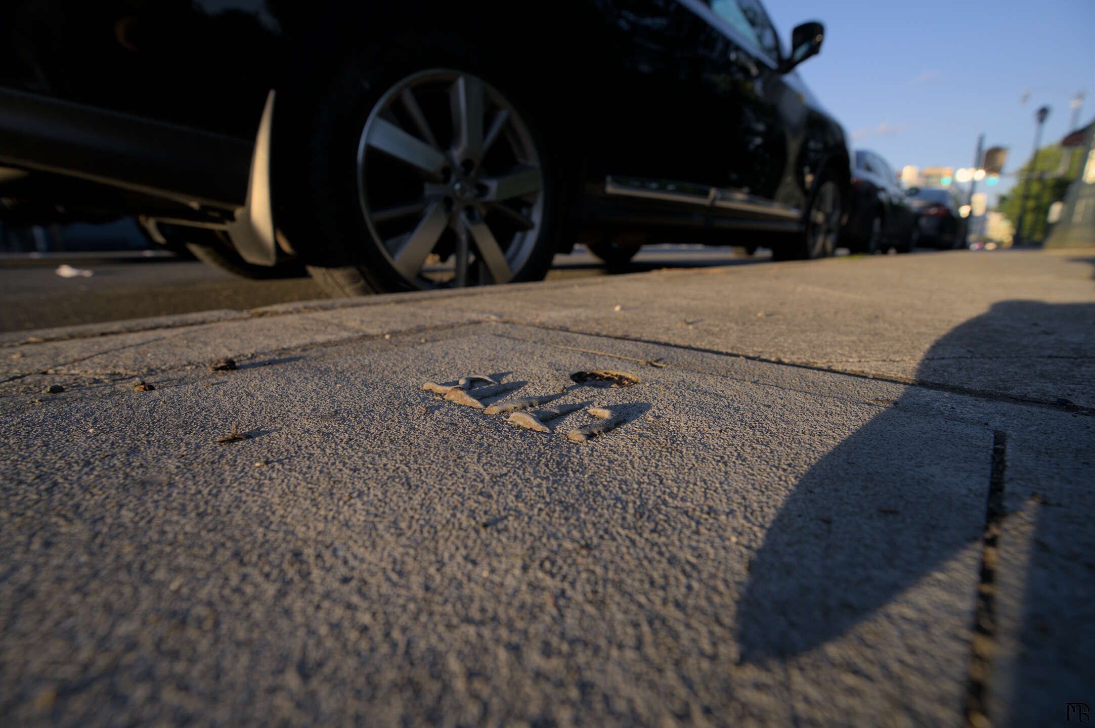 Concrete letters on sidewalk by car