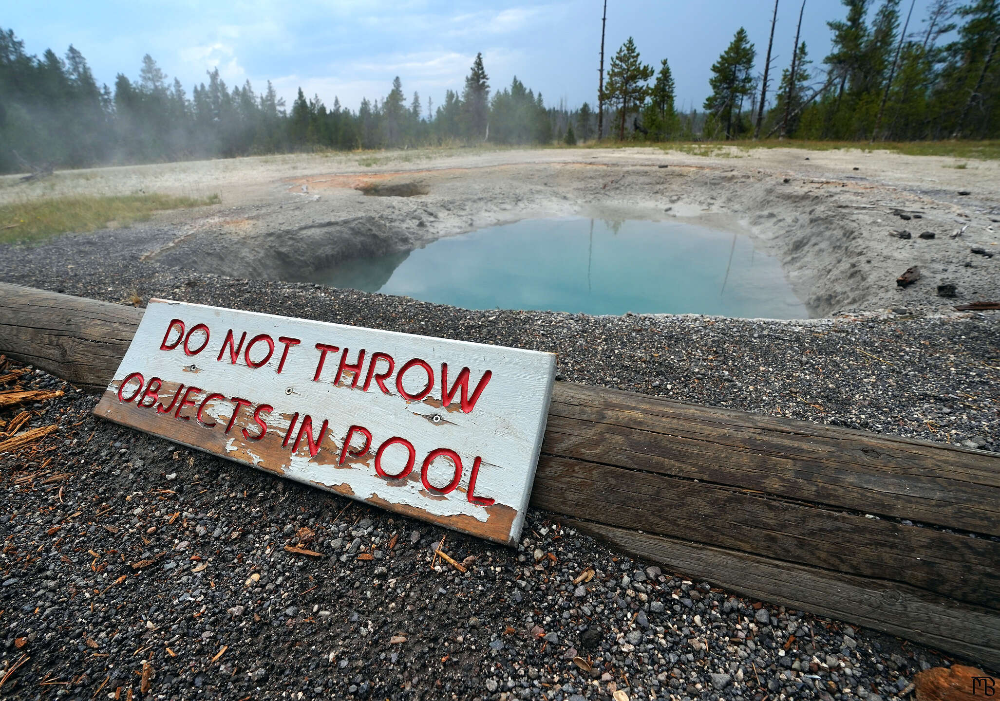 Yellowstone do not throw object in pool near blue hot spring