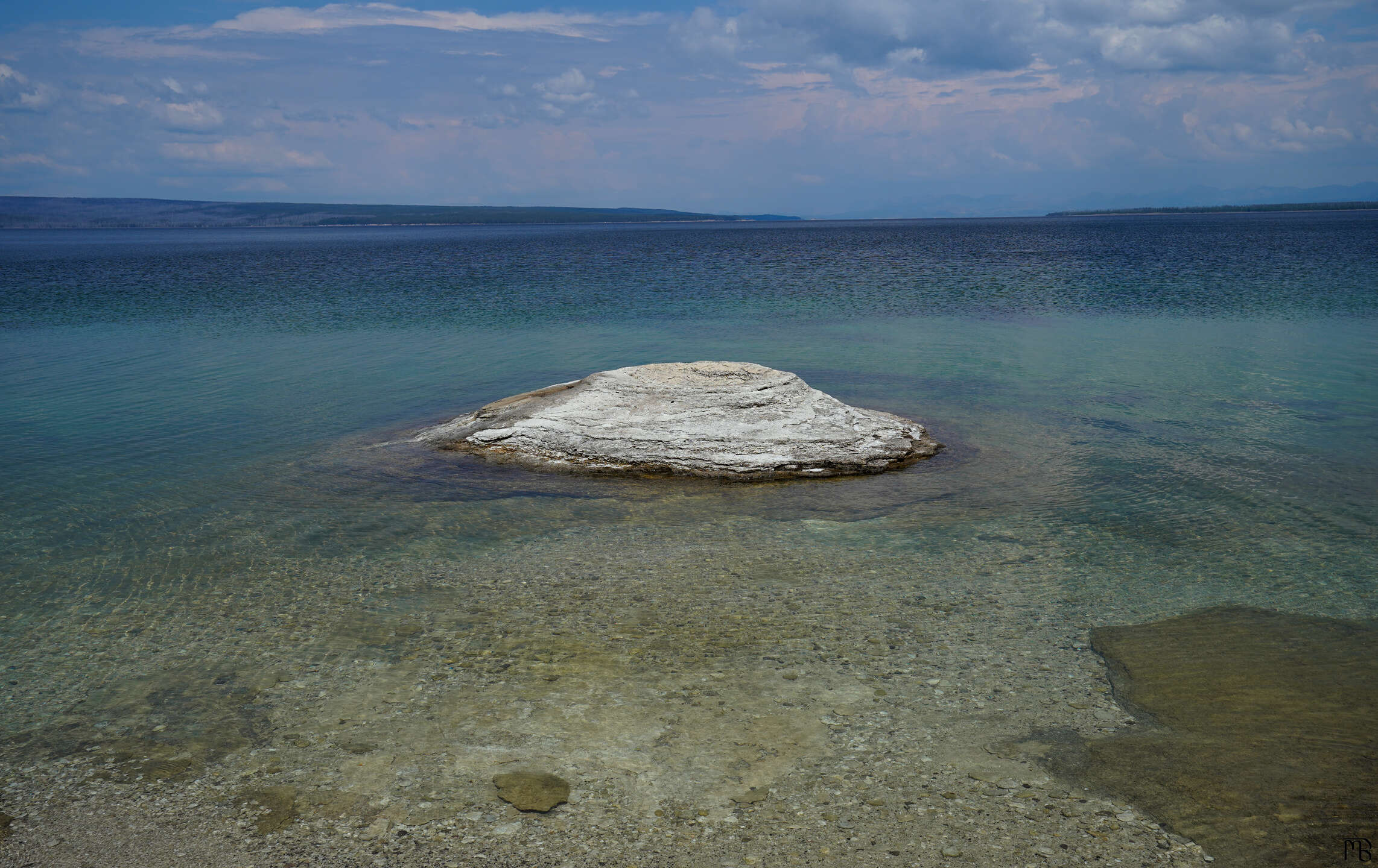 Rock floating above blue lake at Yellowstone