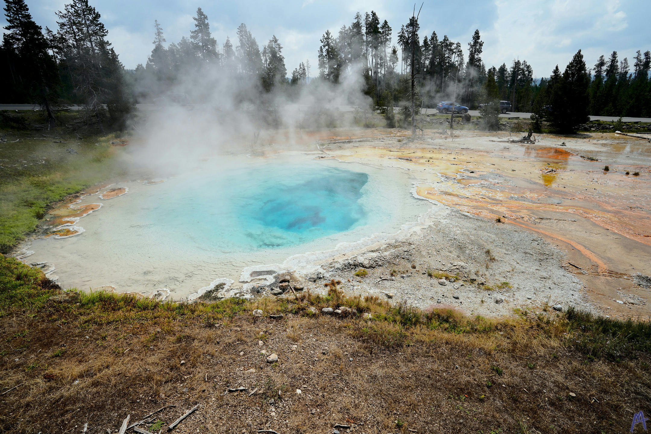 Blue and orange hot spring near road at Yellowstone