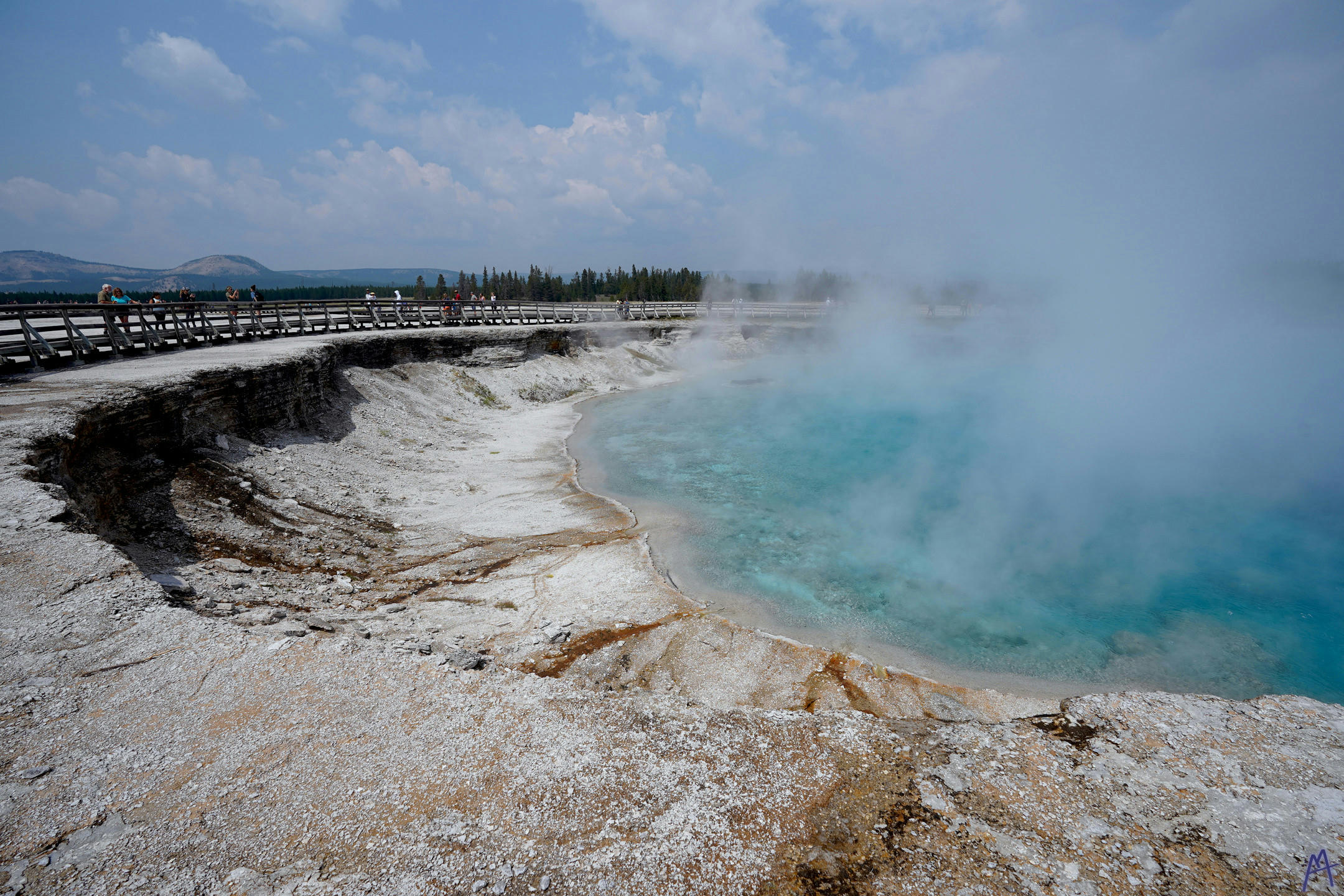 Very blue hot spring bellowing steam at Yellowstone