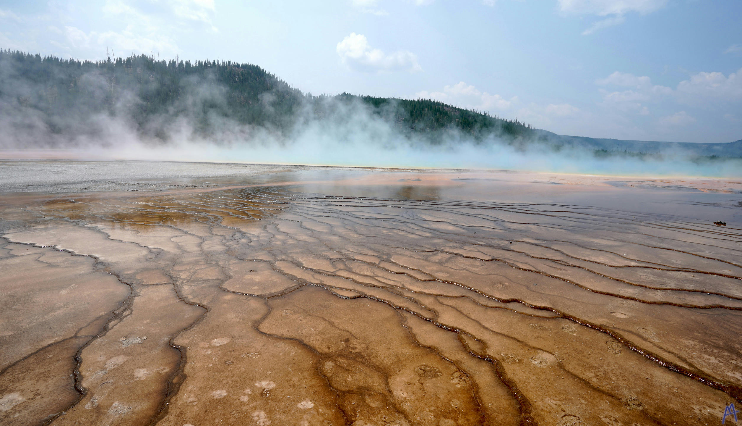 Orange terrace leading to steam at Yellowstone