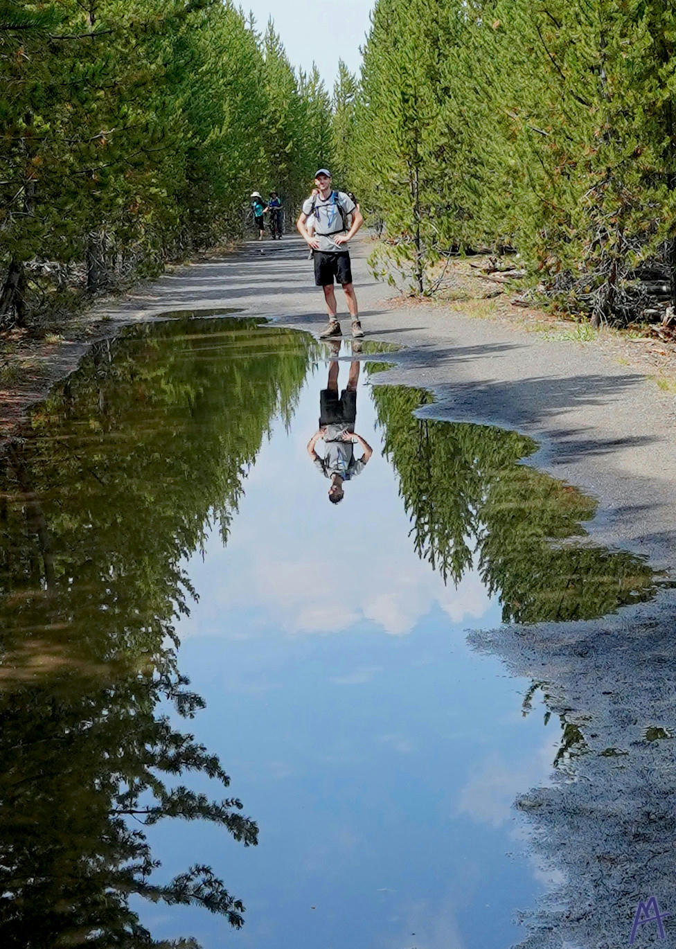 Brother and his reflection in a puddle at Yellowstone