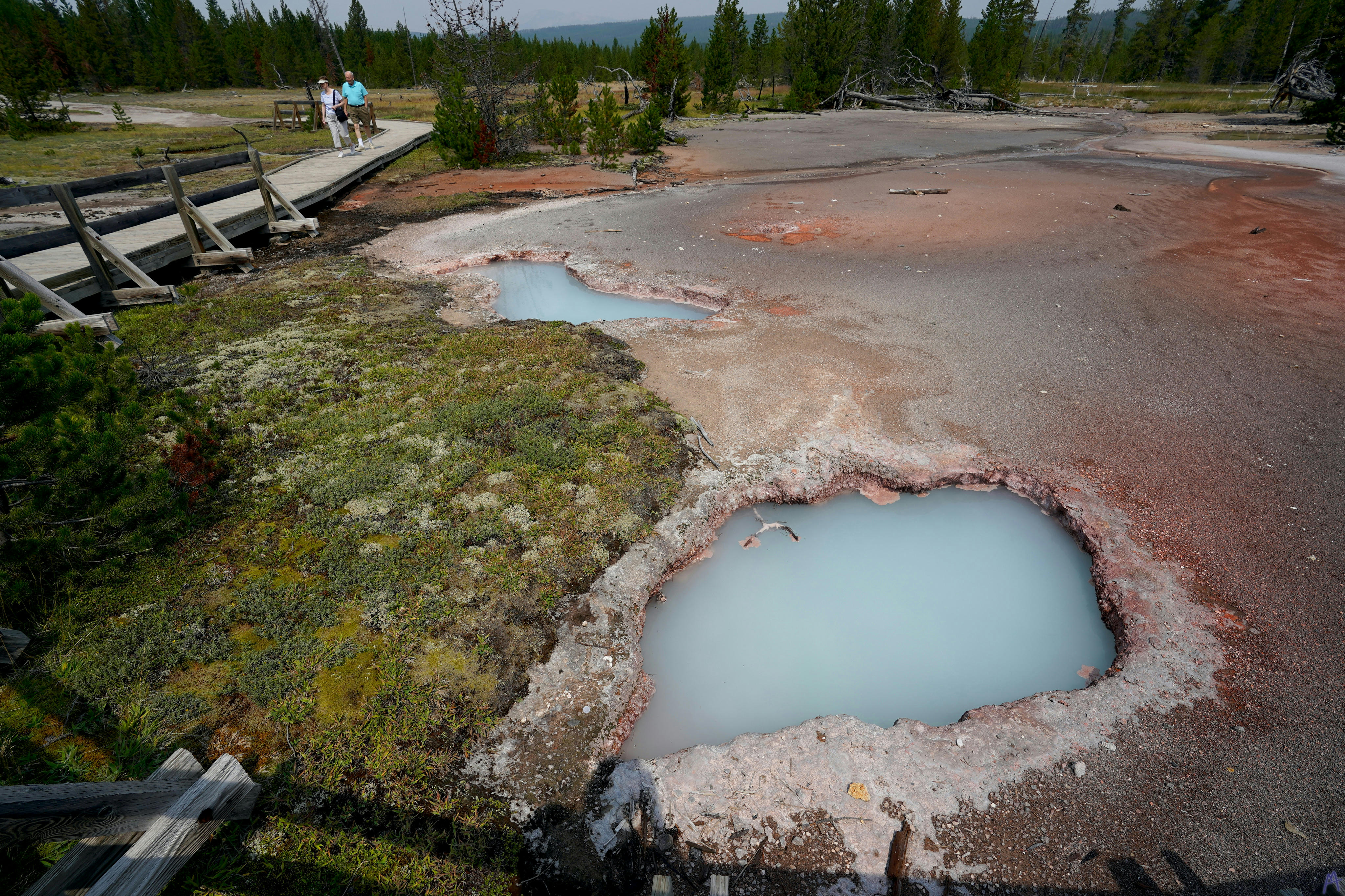 Cloudy blue hot spring near orange ground at Yellowstone