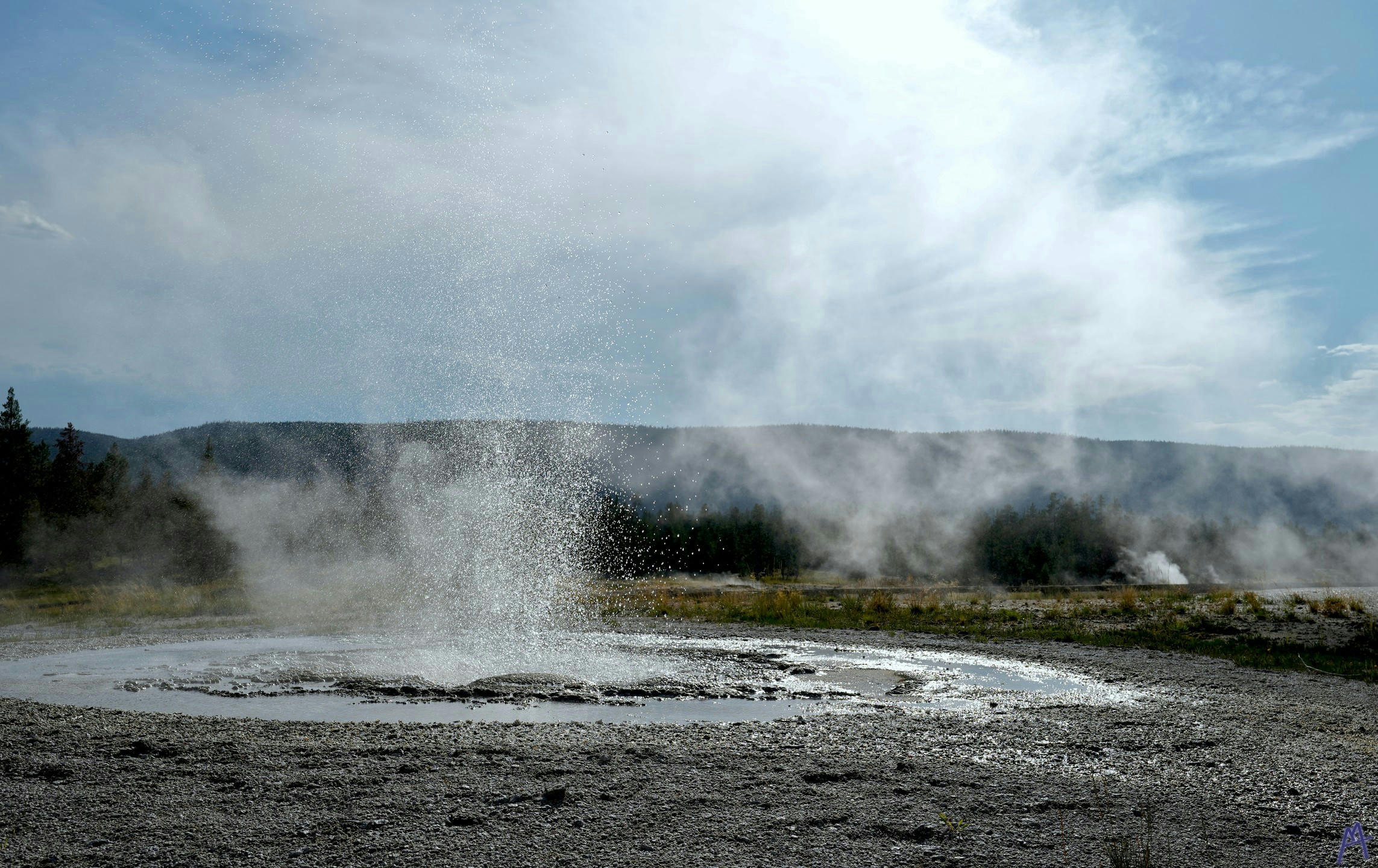 Geyser sprouting with mist in distance at Yellowstone