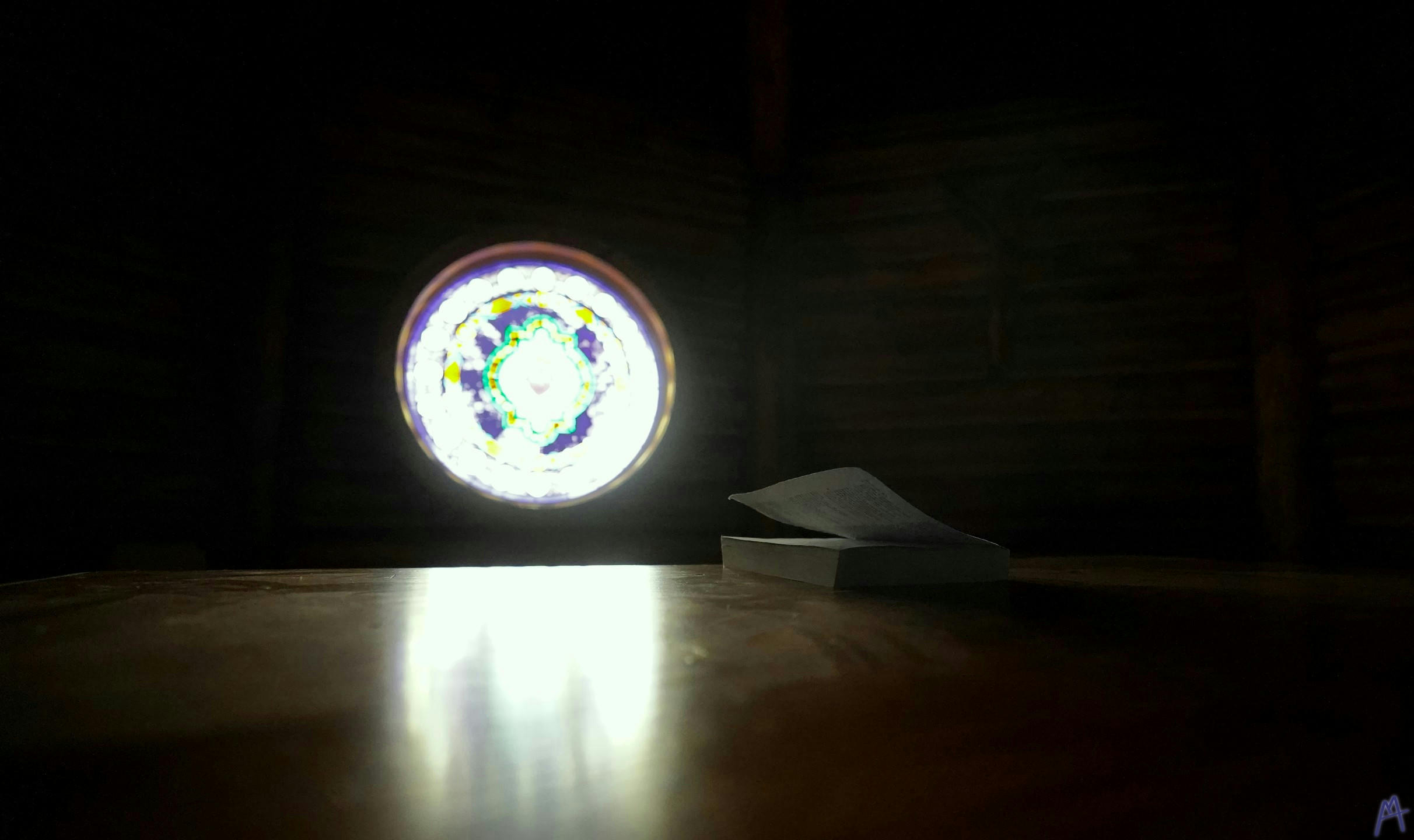 Bible illuminated through small stain glass window at Grand Teton