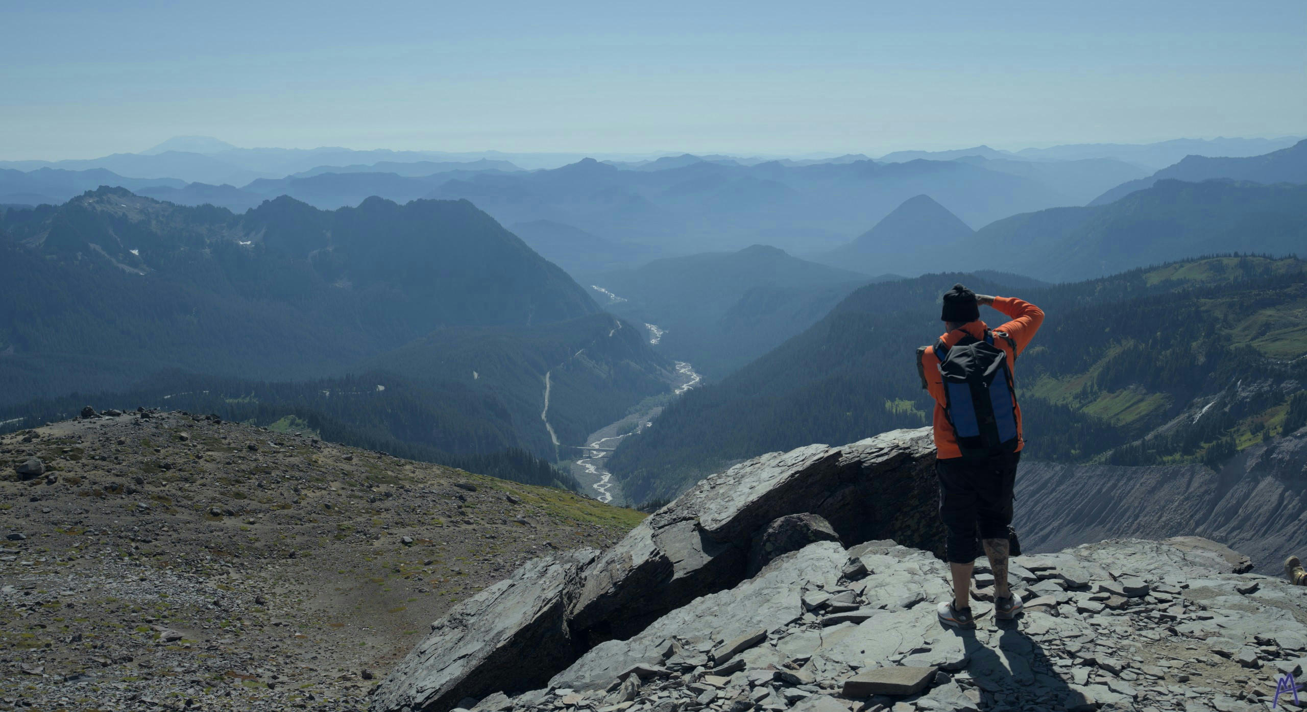 Hiker taking a photo of the mountain across the horizon at Rainier