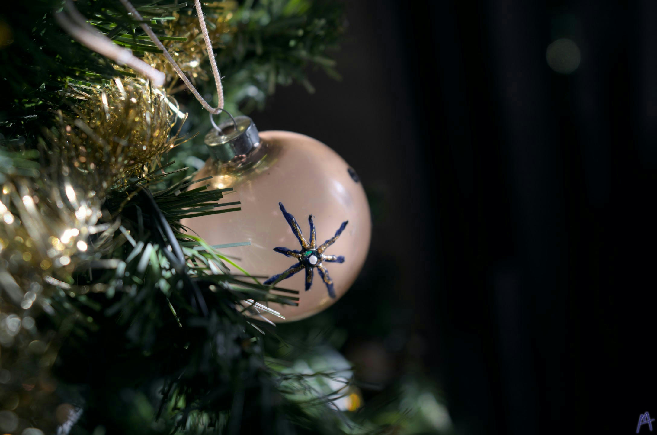 A white and blue spherical ornament on a green Christmas tree