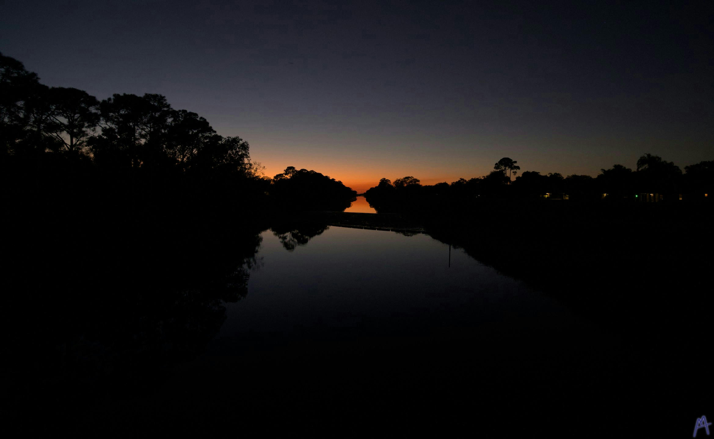 Orange and blue sunset reflected over a canal