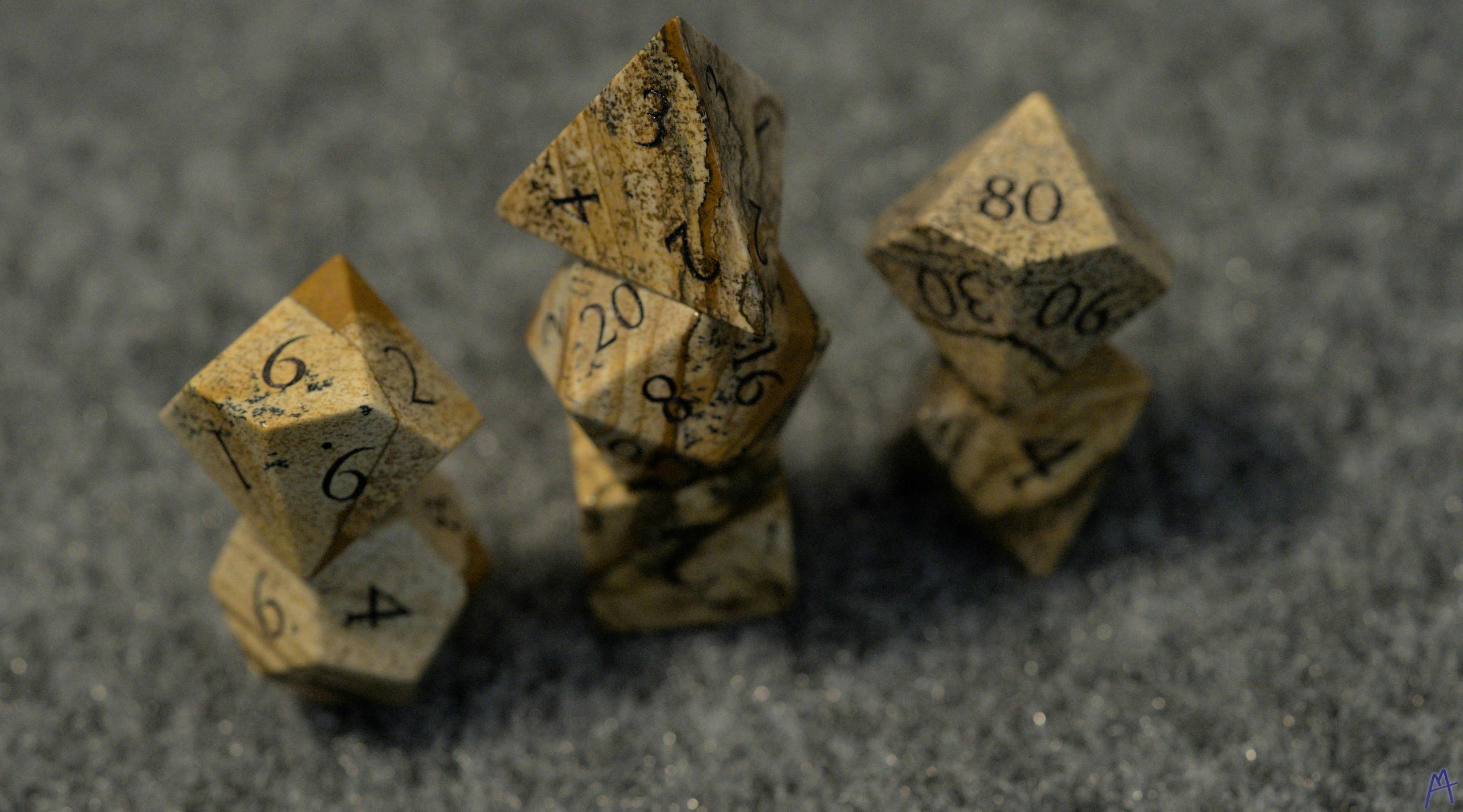 Stone and jasper dice stacked on a table