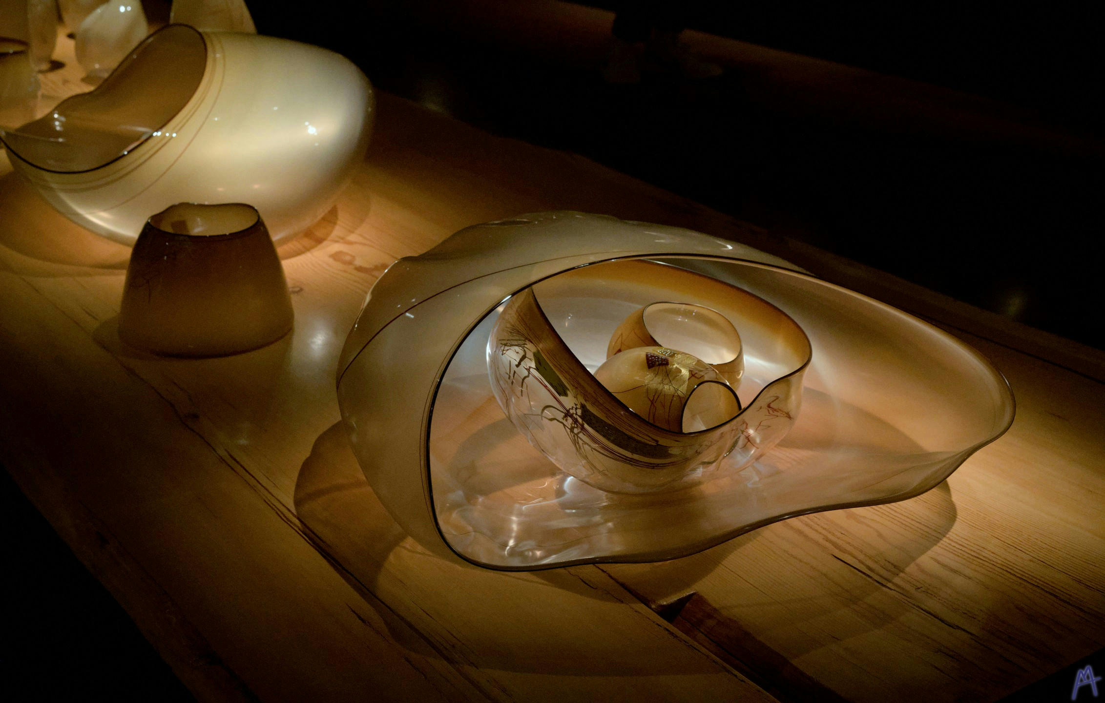 Glass sculpture on a bench in dim lighting