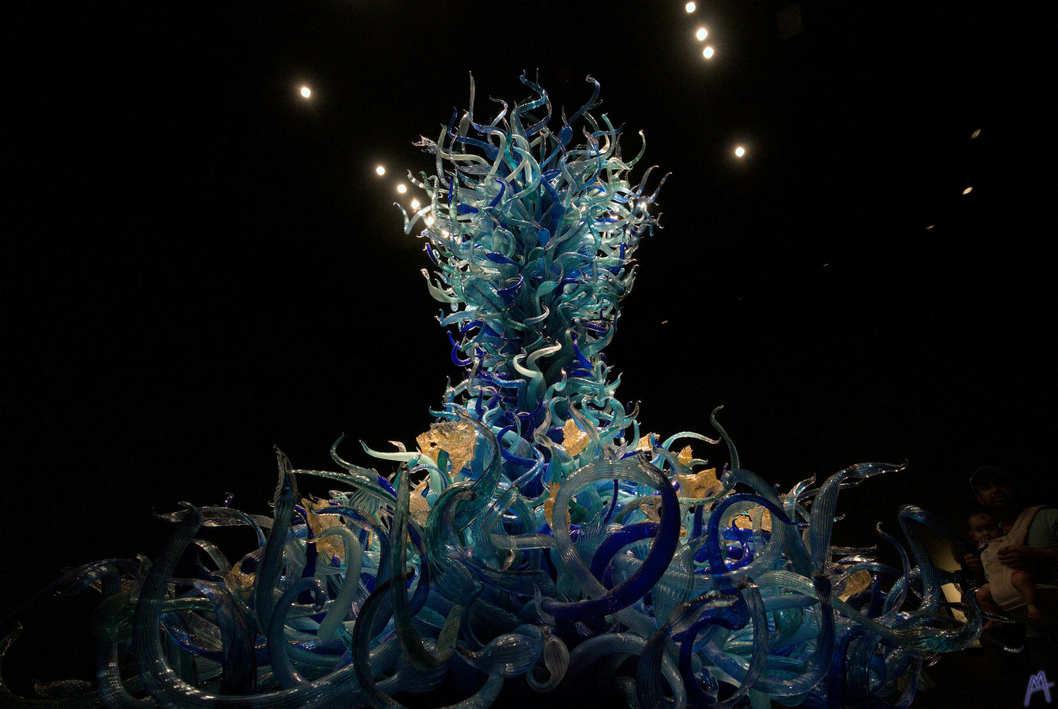 Blue and yellow glass structure rising towards lights